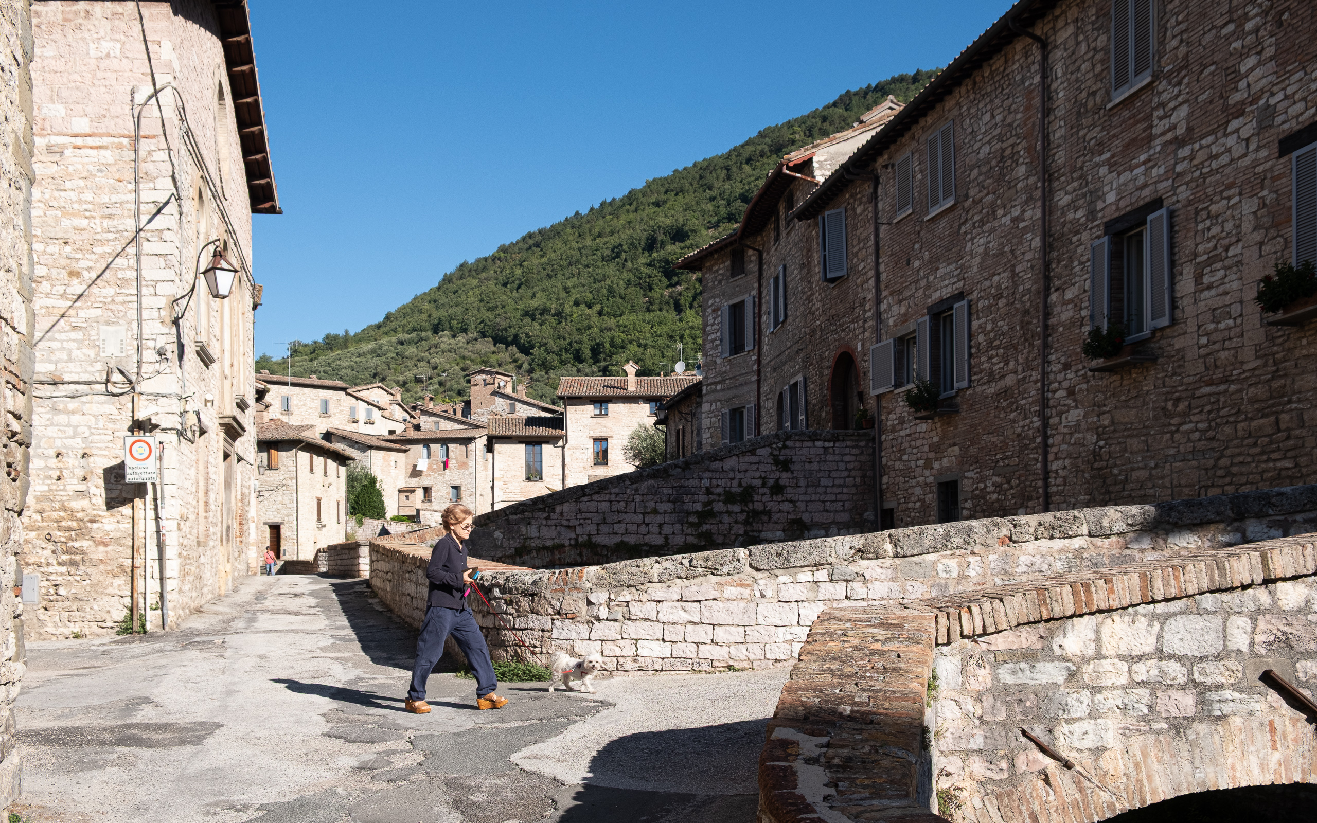 Abschied von Gubbio – eine Dame mit ihrem Hund an der Brücke
